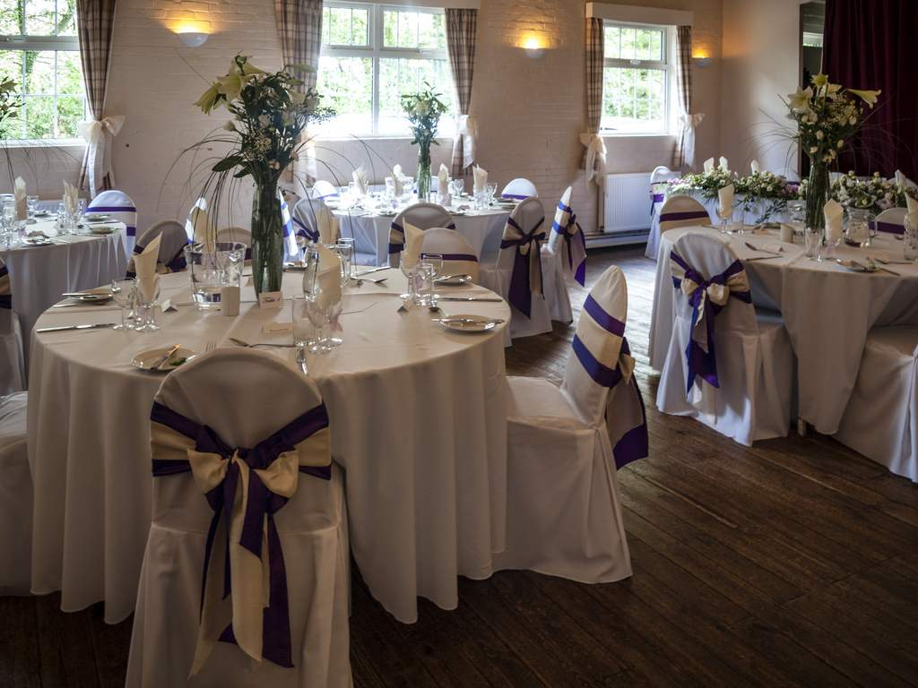 Inside Markbeech Village Hall, set up for a wedding reception with dressed tables and chairs